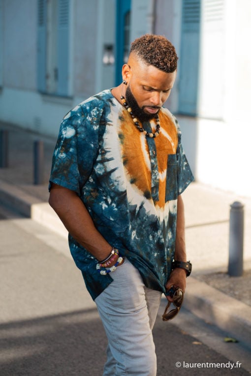 Haut de boubou africain homme en calicot teinté porté avec un collier et des bracelets en perles
