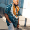 Haut de boubou africain homme en calicot teinté porté avec un collier et des bracelets en perles